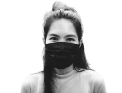a young Asian person masking to protect themselves and others from COVID