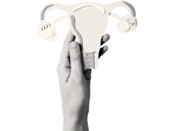 Black and white image of a hand holding a paper cutout of a uterus