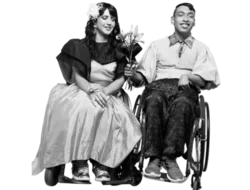 two people in wheelchairs, one white, one brown, holding flowers and dressed for a formal date