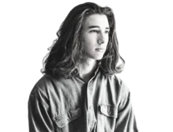a white teen person with long hair in a denim shirt looking contemplative