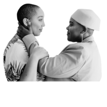 Two Black gender nonconforming people. The person on the right has their hand laid on the person on the left's face in a romantic gesture.