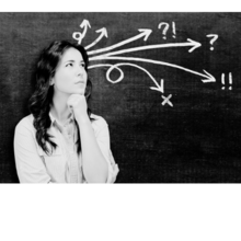 Image of a woman with long black hair. She is standing against a chalkboard and arrows pointing to various question marks are coming out of her head.
