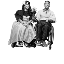 two people in wheelchairs, one white, one brown, holding flowers and dressed for a formal date