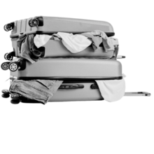 Two suitcases stacked on top of each other with clothes sticking out of them. 
